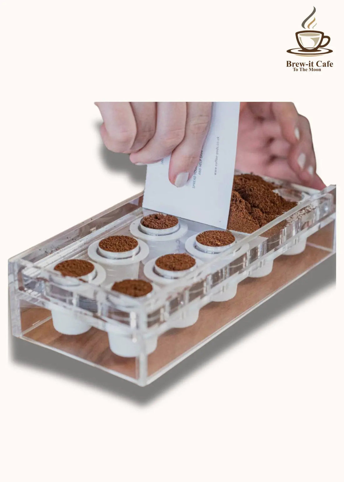 Hand filling reusable coffee pods with ground coffee using clear pod holder