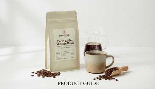 Decaf Coffee Mexican Roast bag with ceramic mug, coffee beans, scoop, and glass carafe on white table.