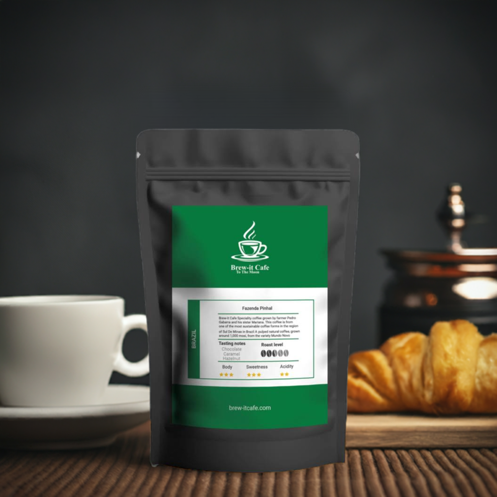 Brew-itCafe single-origin coffee package in black bag with green label placed on wooden table with cup and croissant
